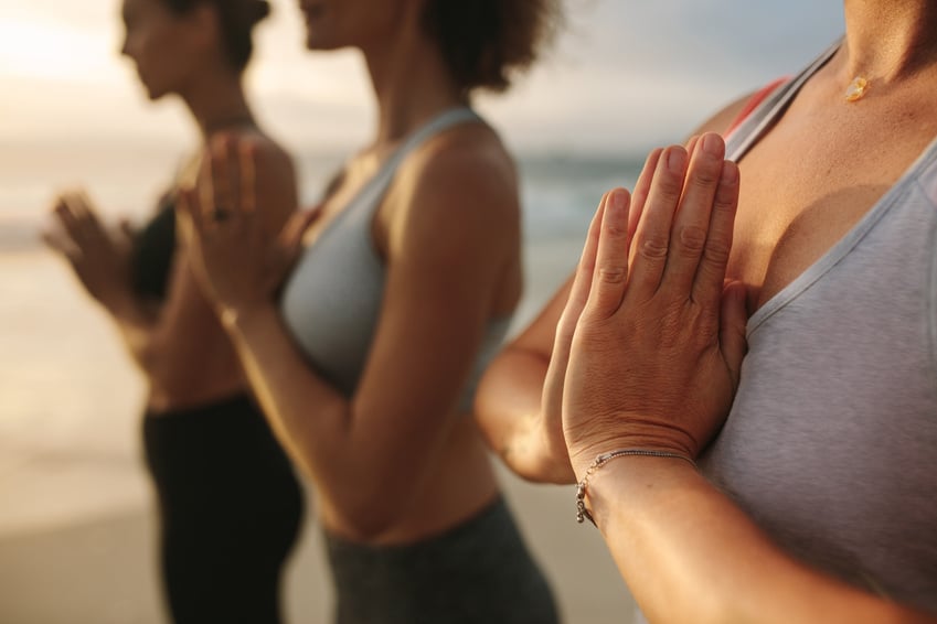 Active Females Practicing Yoga at the Beach